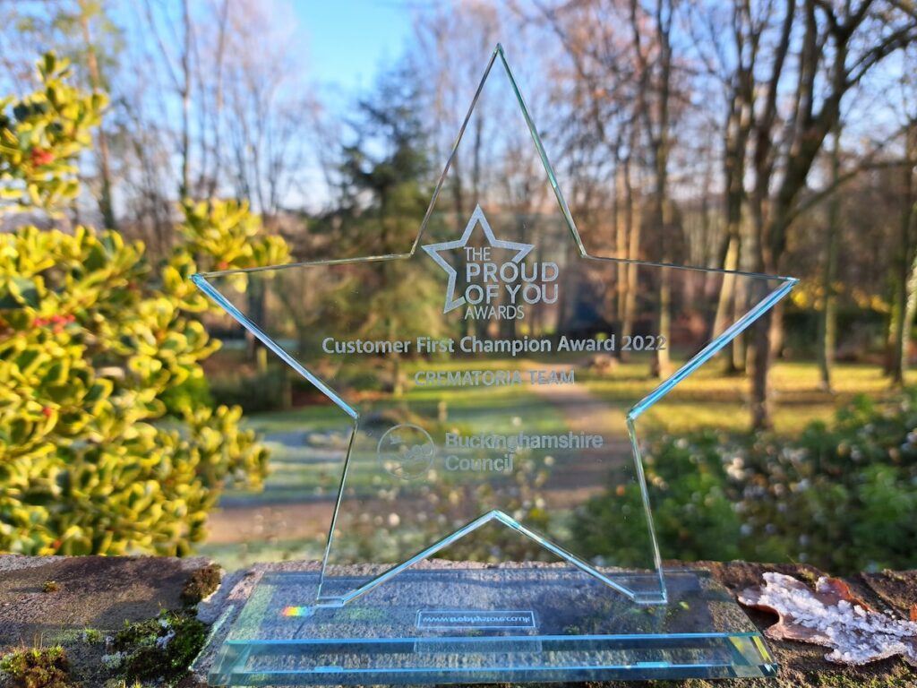 Glass star shaped trophy message reads 'Customer First Champion Award 2022'